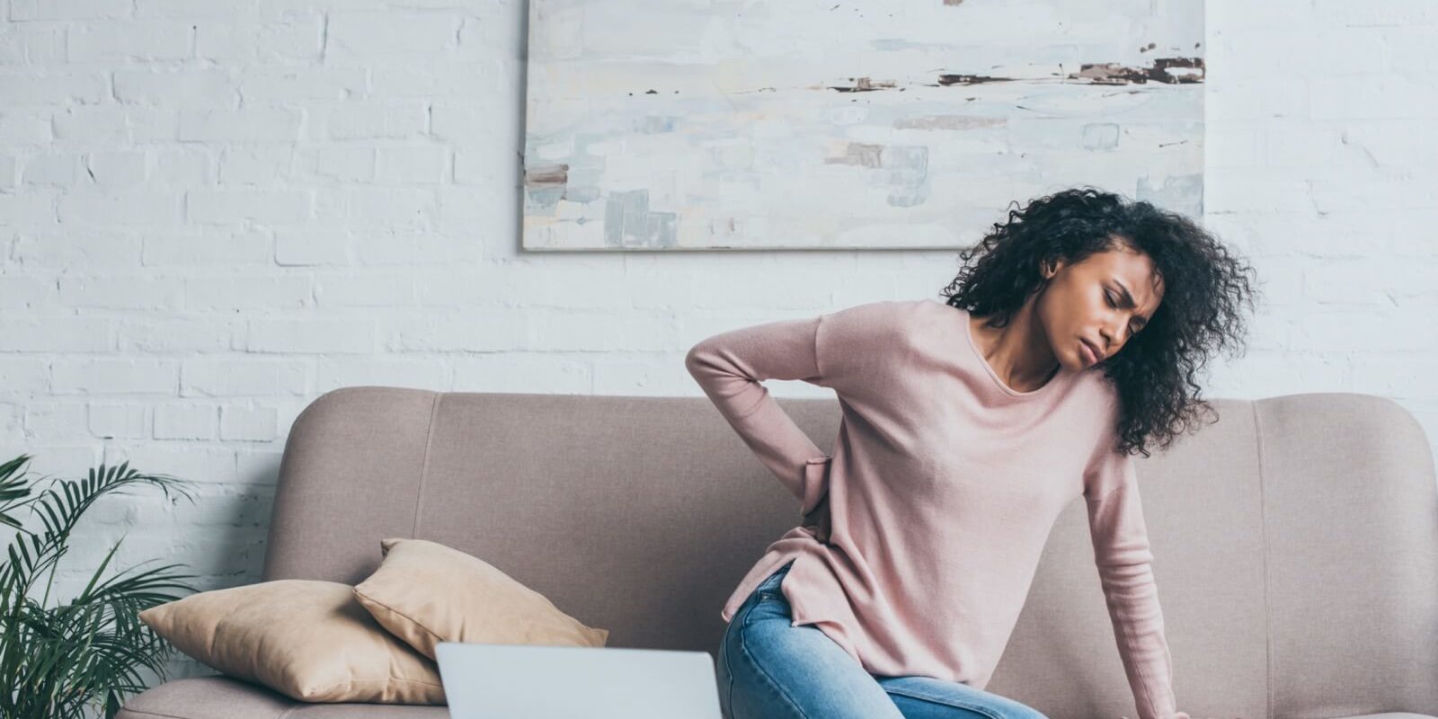 woman on couch with back pain